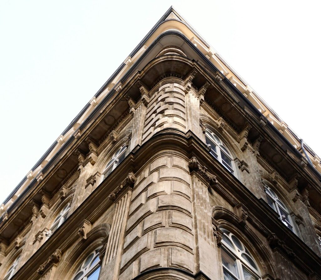 Upward corner view of a classic European building facade with ornate architecture.